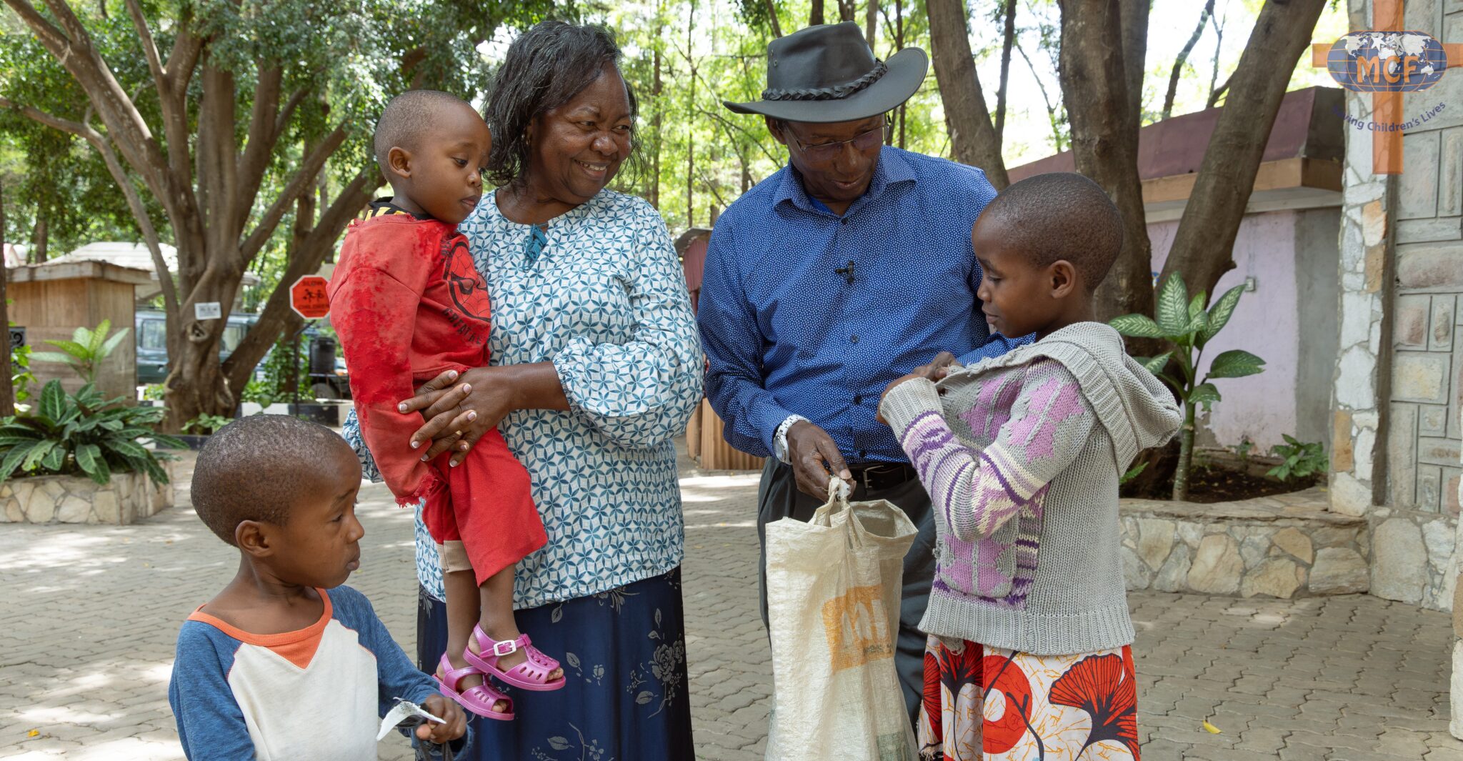 A man in a cowboy hat and a woman holding a toddler with two children at MCF